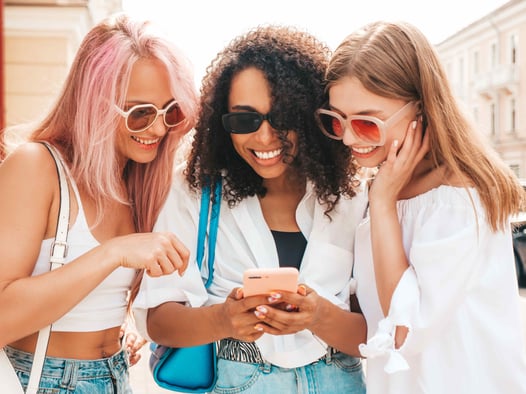 mixed-woman-friend-group-smiling-at-phone