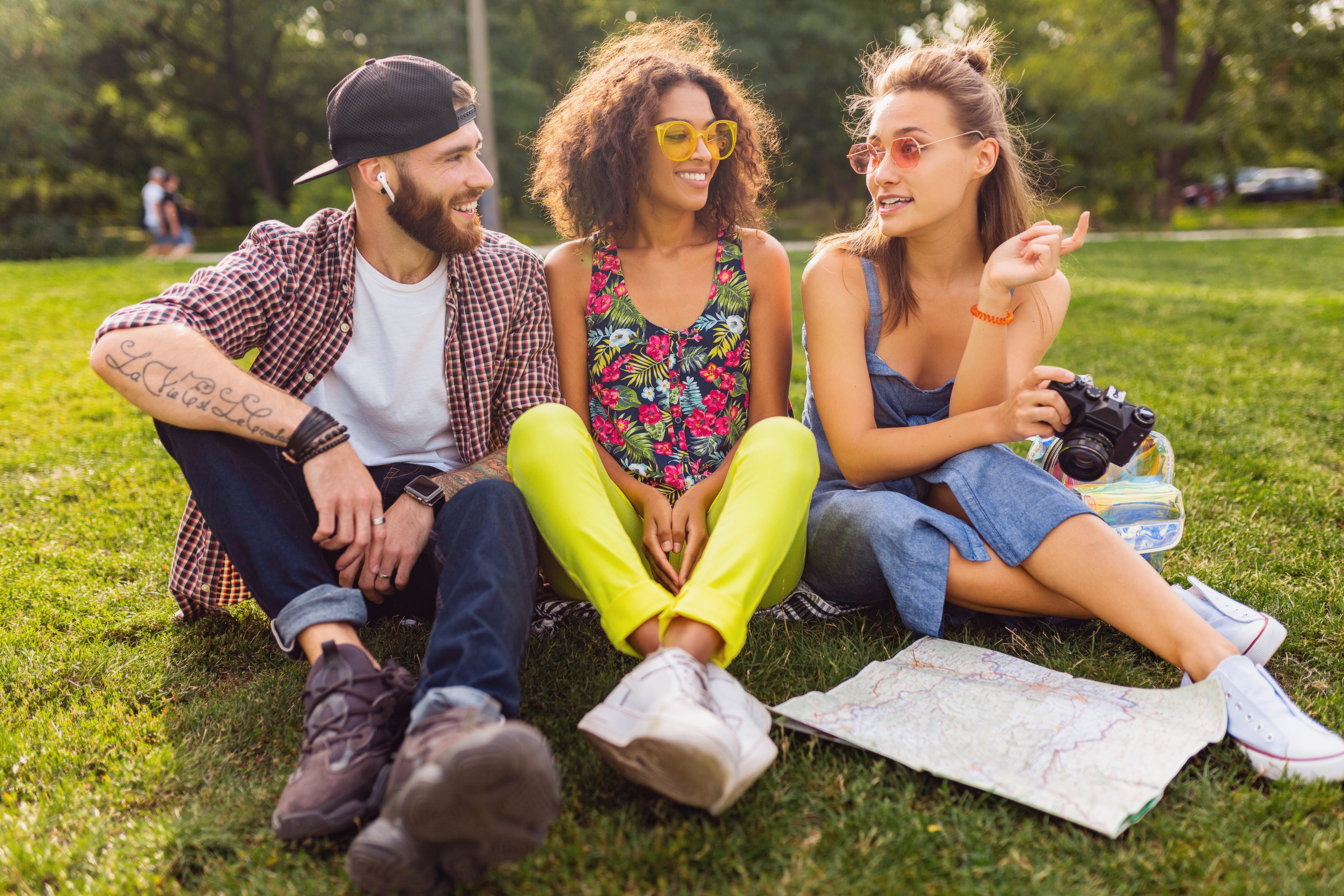 happy-young-company-friends-sitting-park-traveling-looking-map-sightseeing-man-women-having-fun-together-colorful-summer-hipster-fashion-style-taking-photo-camera-talking-smiling