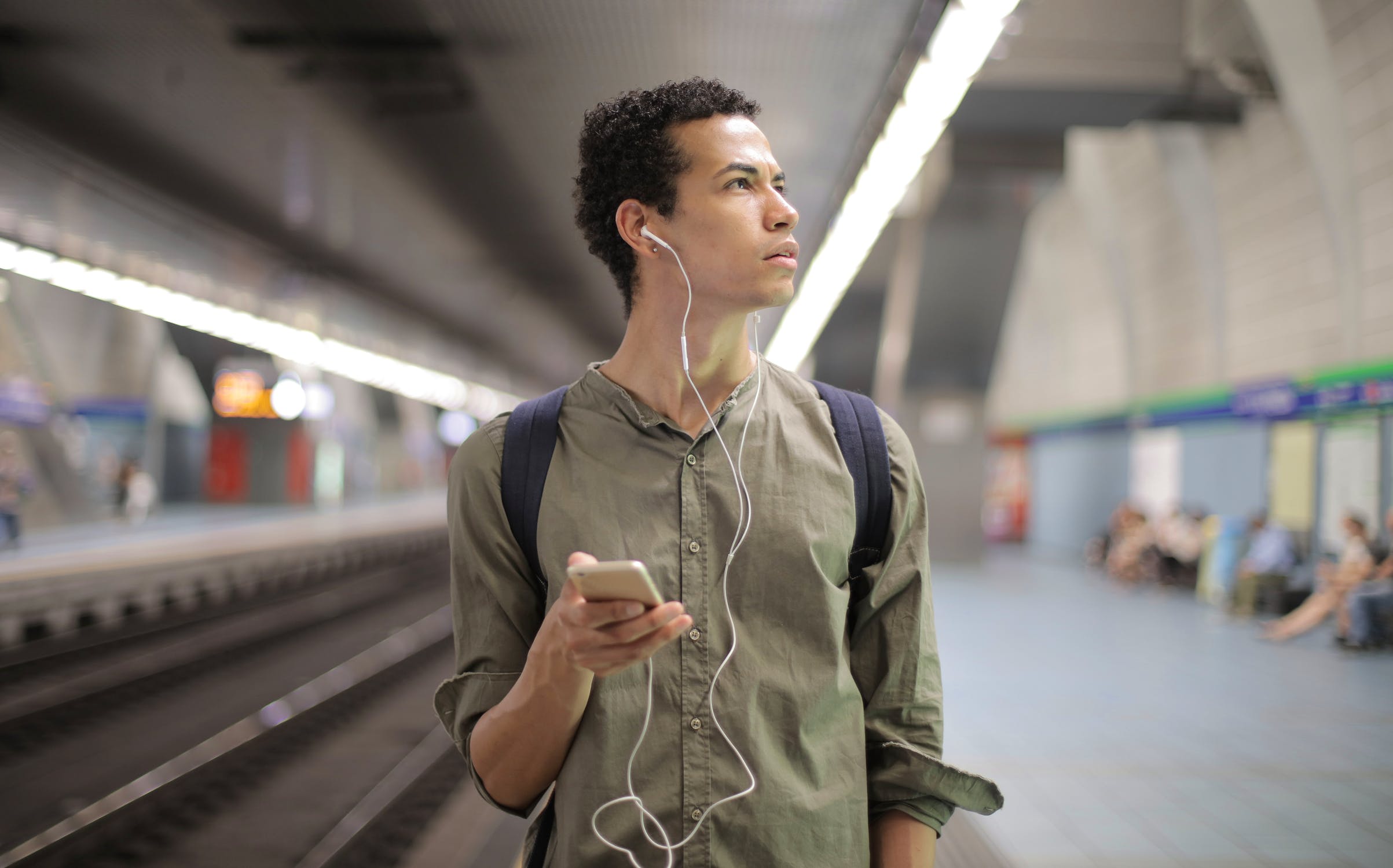 Jongeman die luistert naar muziek op een metrostation